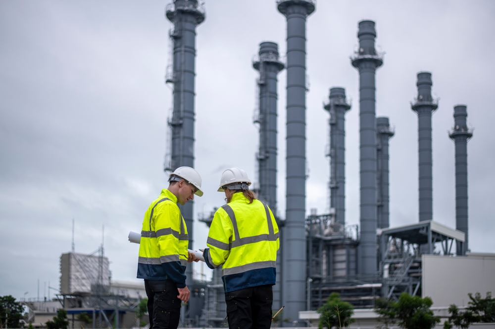 Two employees of an oil facility using a secure communication application for better coordination in the field.